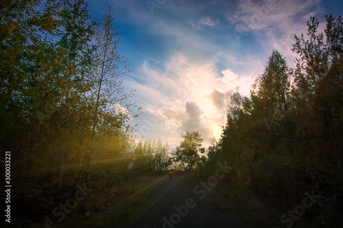 Sunset in the mountains in autumn. Mountain forest landscape under evening sky with clouds in sunset.