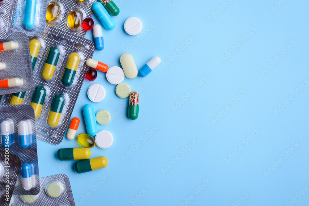 Top view of the pills on the blue background. The drug capsule pills on the floor. Concept of medicine background Top view of the pills on the blue background. The drug capsule pills on the floor. Concept of medicine background