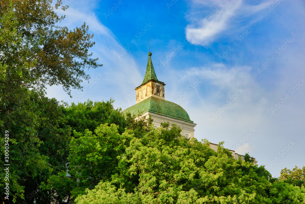 Moscow, Russia - June 29, 2018: the spire of the building of the educational house on Moskvoretskaya embankment in Moscow. Big green tree in front of the house