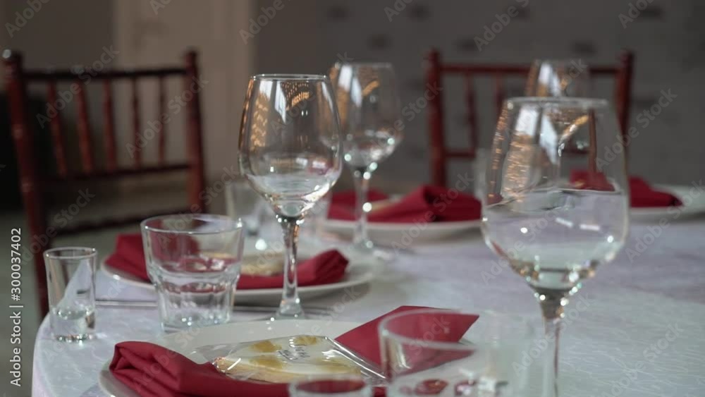 Glasses, plates, Cutlery and napkins. Decorated tables with flowers for the party. Wedding reception, birthday, anniversary Glasses, plates, Cutlery and napkins. Decorated tables with flowers for the party. Wedding reception, birthday, anniversary