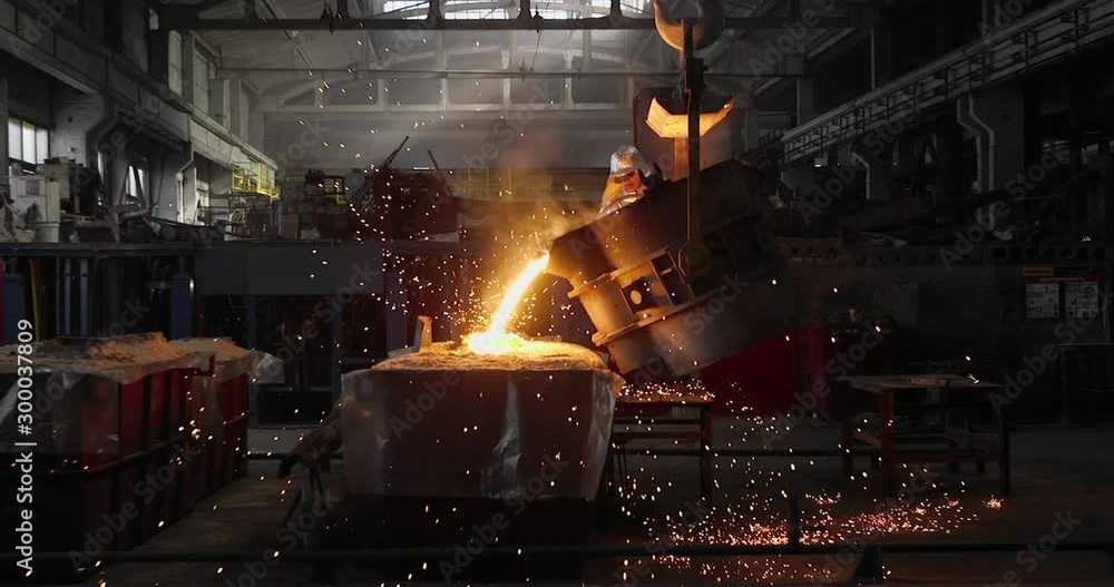 Hard work in the foundry. Pouring molten steel. Liquid steel pouring ...