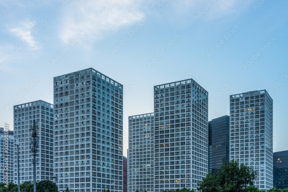 green trees front of modern glass office building.