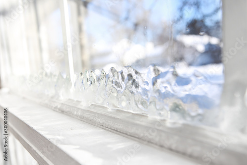Ice forming on the inside glass of a drafty window in winter photo