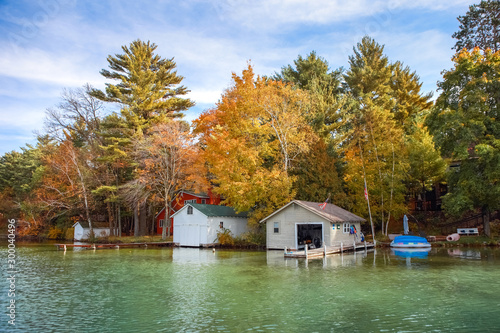 Boat houses on a lake during autumn photo