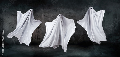 Obraz na plátně Ghosts in sheets dancing and floating in the air