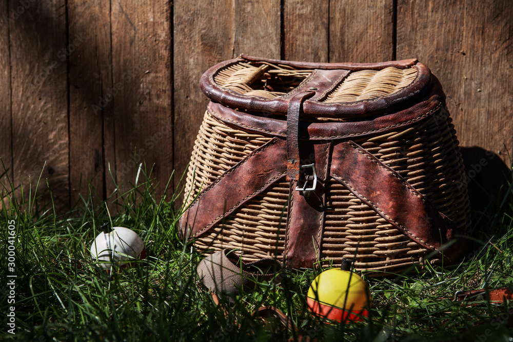 Fishing bobbers with vintage Creel basket outside in the grass Stock Photo