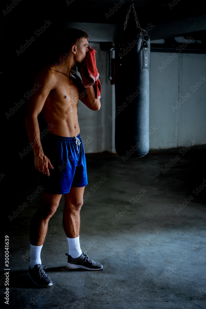 Fit man taking a break from working out at the gym