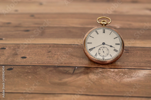 Pocket watch on a wooden surface.