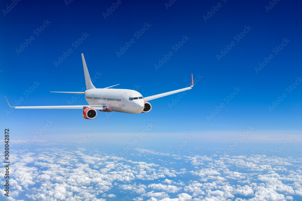White airplane flying above cloud - obrazy, fototapety, plakaty 