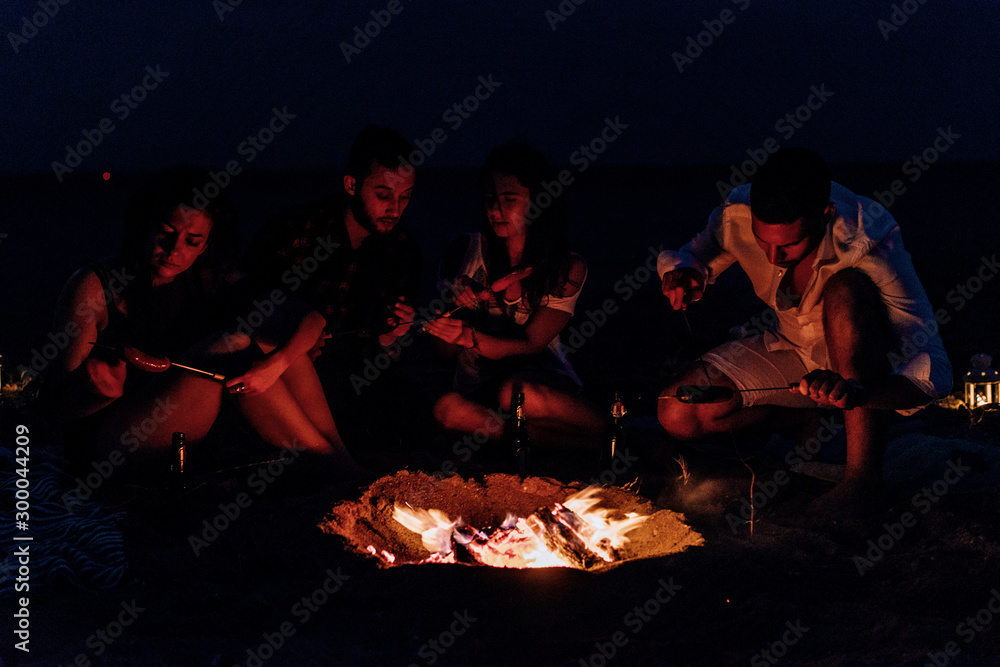 Fototapeta premium Happy friends having fun around bonfire
