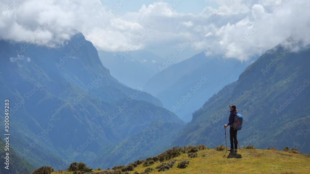 Active hiker admiring beautiful landscape in Nepal mountains.Way to Everest base camp.Static handled zoom shot Active hiker admiring beautiful landscape in Nepal mountains.Way to Everest base camp.Static handled zoom shot