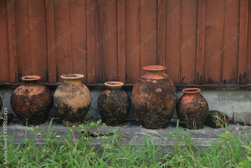 Okinawan (Ryukyuan) Pottery Placed outside a Wooden House Okinawan (Ryukyuan) Pottery Placed outside a Wooden House
