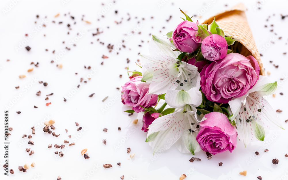 Bouquet of flowers in a waffle cone on a chocolate chip pattern. Rose and alstrameria on a white background. Theme for greeting cards or wedding invitations. Copy space