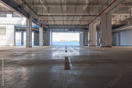 Backlit perspective view of interior space of concrete building warehouse