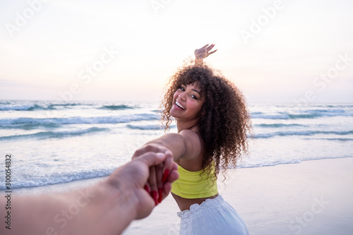 Photos Girl holding male hand and running on tropical exotic beach to the ocean