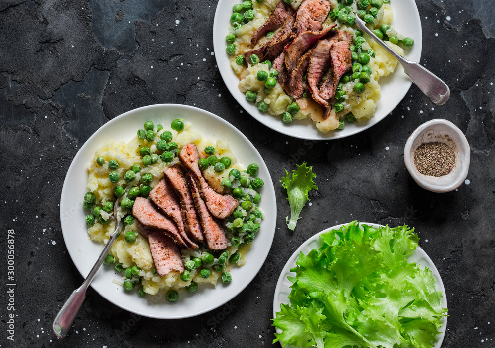 Beef steak with mashed potatoes and creamy green peas sauce on dark background, top view Beef steak with mashed potatoes and creamy green peas sauce on dark background, top view
