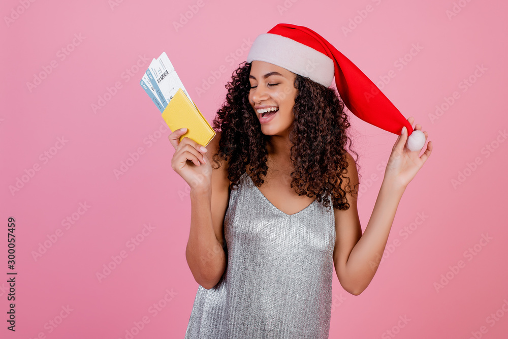 black woman with plane tickets and passport wearing santa hat isolated over pink black woman with plane tickets and passport wearing santa hat isolated over pink