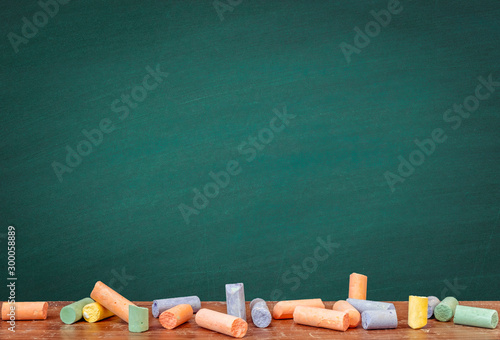 Group of colorful chalk rubbed out on blackboard or chalkboard background, can be use as concept for school education, dark wall backdrop , design template , etc. photo