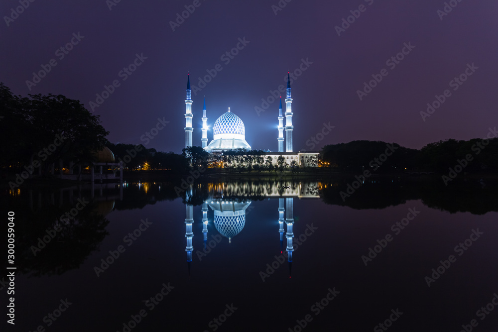 shah alam, malaysia mosque during sunrise with reflection from the lake
