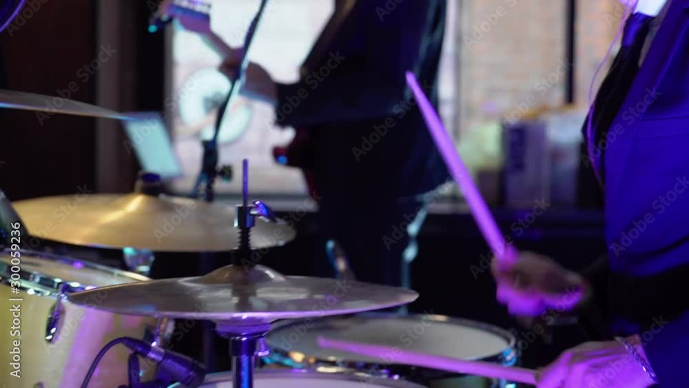 Drummer playing drums at concert. Musician with drum sticks plays percussion at stage Drummer playing drums at concert. Musician with drum sticks plays percussion at stage