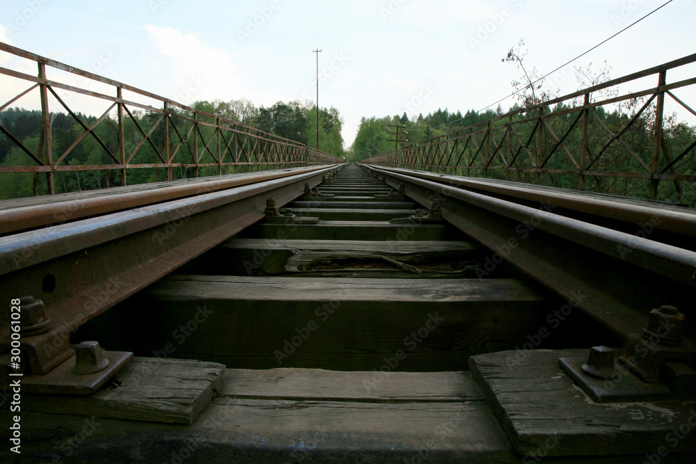 Fototapeta premium Train track on the historic iron railway bridge - Pilchowice Lake - Lower Silesia, Poland. industrial abstraction.