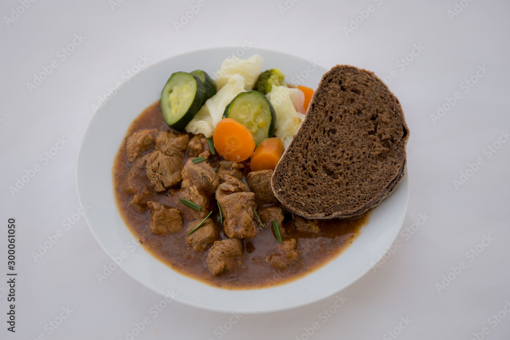 beef casserole in the bowl with steamed vegetable