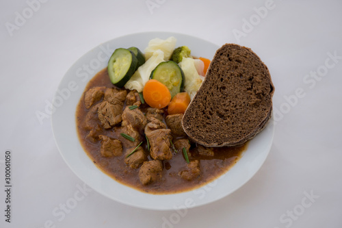 beef casserole in the bowl with steamed vegetable