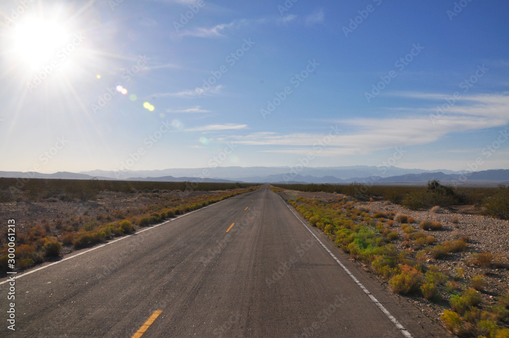 Empty two lane road to horizon with blue sky background