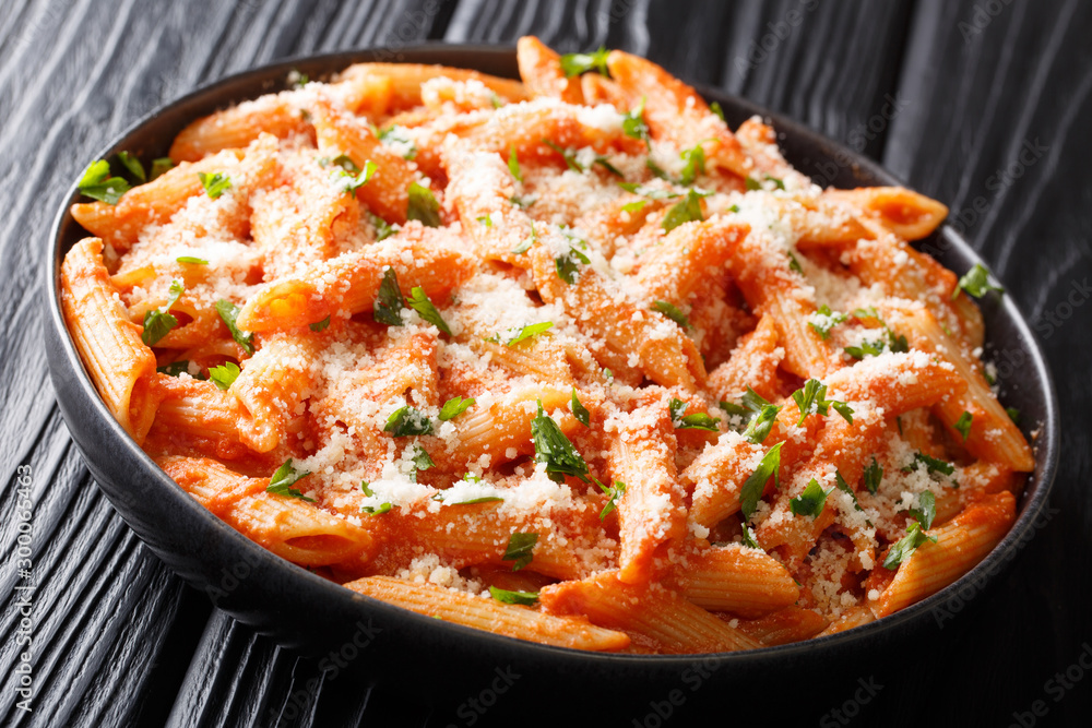 Penne Alla Vodka is thick and hearty pasta dish with a delicious creamy vodka tomato sauce close-up in a plate. horizontal Penne Alla Vodka is thick and hearty pasta dish with a delicious creamy vodka tomato sauce close-up in a plate. horizontal