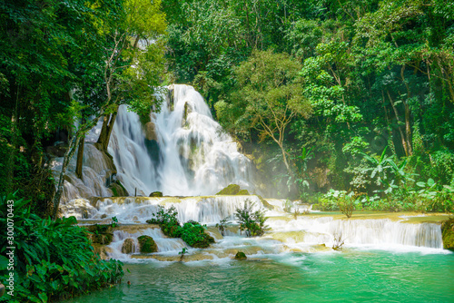 Fototapeta Naklejka Na Ścianę i Meble -  Kuang Si waterfalls close to the popular town of Luang Prabang, on the Mekong River in Laos. A three level waterfall with jade green pools surrounded with lush green tropical jungle. No people.