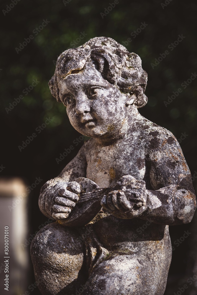 statue of boy playing instrument in garden