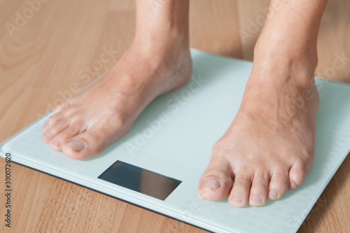 Healthy diet, fitness and weight loss concept. The legs of a young woman on the scales. Checking the weight.
