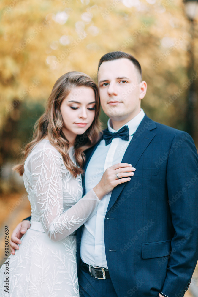 Autumn wedding in European style. Beautiful couple in suit and white dress in Park. Autumn wedding in European style. Beautiful couple in suit and white dress in Park.
