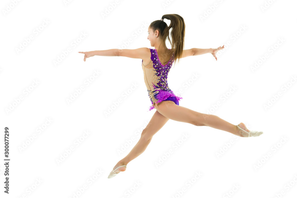 The girl gymnast performs a jump. The girl gymnast performs a jump.