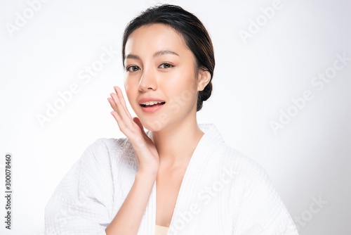 Beautiful young Asian woman touching soft cheek and smile with clean and fresh skin. Happiness and cheerful with, isolated on white background, Beauty and Cosmetics Concept,