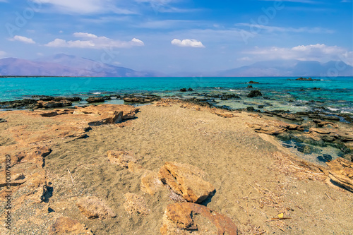 Fototapeta Naklejka Na Ścianę i Meble -  tranquillity and silence , abandoned beach with azure water, rocks on coast, beautiful turquoise sea with mild surf, deep blue sky with clouds and mountains on background, Mediterranean landscape