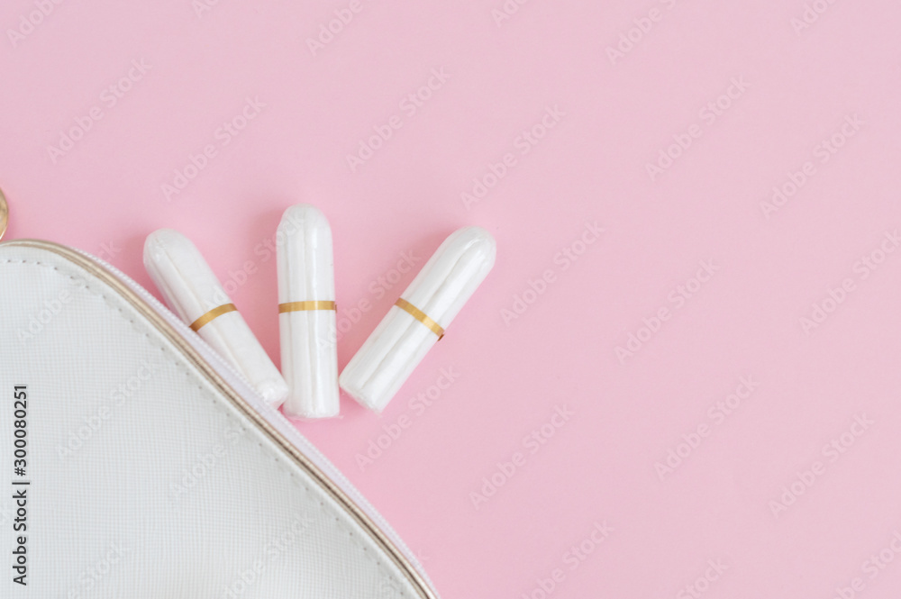 tampons and cosmetic bag on pink background. woman period concept.