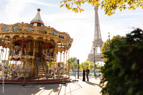 Romantic date, honeymoon, travel, marriage proposal in Paris. Couple in love walking near the Eiffel tower and Parisian Сarousel