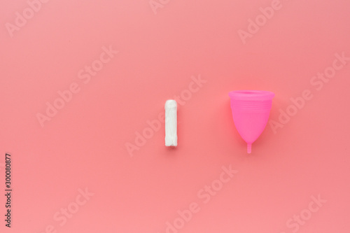 Menstrual cup and tampon on pink background. Alternative feminine hygiene product during the period. Women health concept. Copy space. Eco friendly concept, zero waste product. Flat lay, mockup