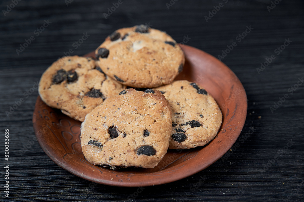 cookies on a black background with a clay plate cookies on a black background with a clay plate