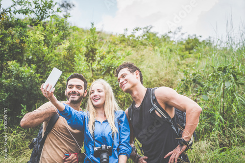 Group friends selfie in the forest park on summer vacation time, friends hiking wild forest an relax at destination point.