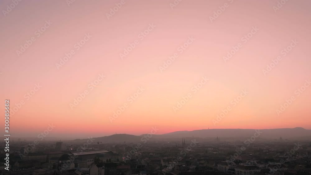 Tilt down aerial shot to a cityscape at a pink sunset, or sunrise. Tilt down aerial shot to a cityscape at a pink sunset, or sunrise.