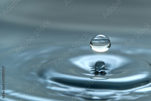 a drop of water hovering in the air before hitting a water surface, which will cause a beautiful splash, close-up photo