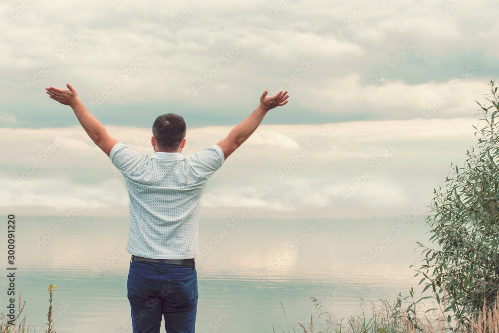 Handsome guy on the lake. Hands up. Liberty. Victory. Handsome guy on the lake. Hands up. Liberty. Victory.