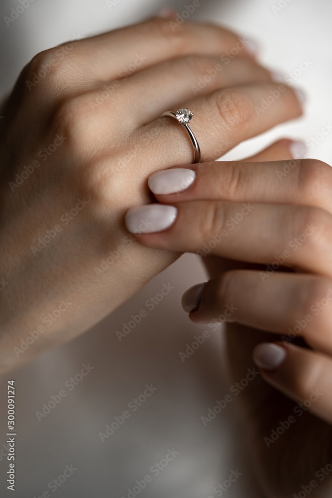 Engagement ring with a diamond on the elegant hand of a beautiful girl.