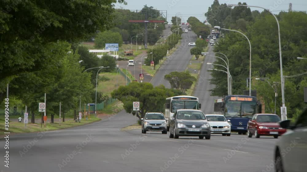 Automobiles speeding on highway amidst trees in city - Johannesburg, South Africa Automobiles speeding on highway amidst trees in city - Johannesburg, South Africa