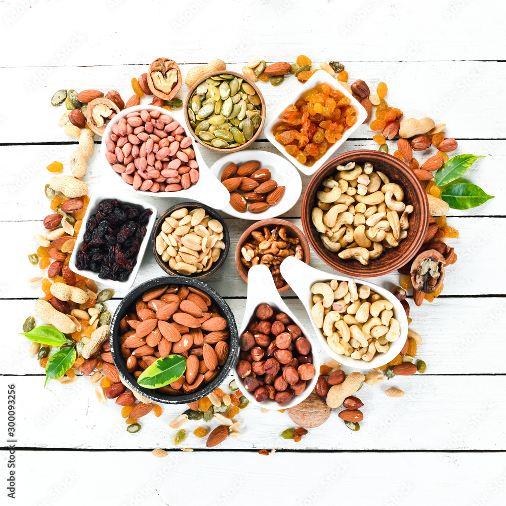 Assorted nuts on a white wooden background. Top view. Free space for your text. Assorted nuts on a white wooden background. Top view. Free space for your text.