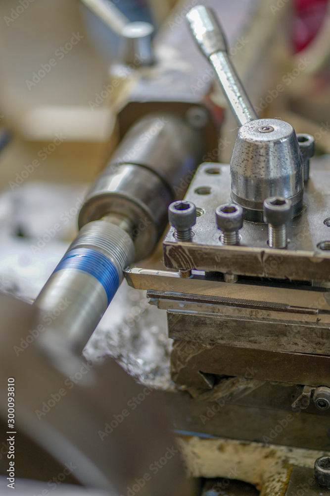 The lathe machine cutting the thread on the steel shaft.The turning machine making the thread on the steel shaft The lathe machine cutting the thread on the steel shaft.The turning machine making the thread on the steel shaft