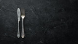 Old cutlery on a black background. Top view. Free space for your text.