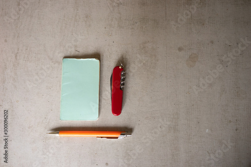 utility knife, pencil and notebook on a concrete table photo